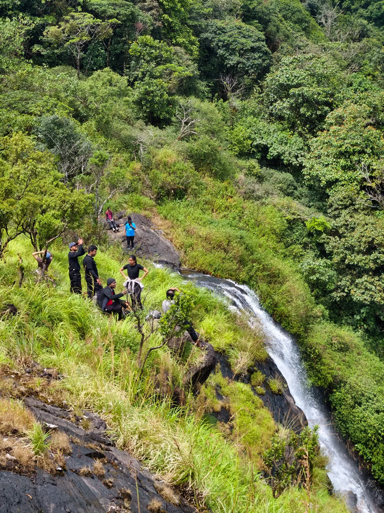 Trekkers beside the waterfall at the top of Ibbani Gudda